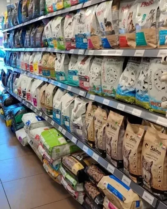 Een gangpad met schappen vol dierenvoeding